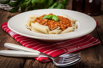 Penne a bolognese on white plate.