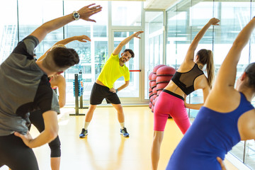 Group of sporty people doing aerobic class on a fitness center.