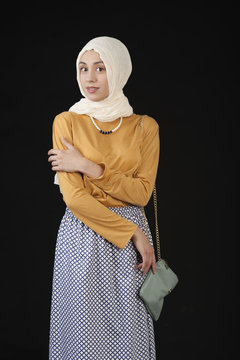studio photo eastern girl in a headscarf and a modern Islamic Clothes on a dark background
