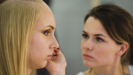 Professional Beauty judge and stylist at work. For a spectacular top models make a bright, expressive makeup. Stylish hairstyle and image
