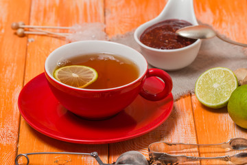 Cup of  tea with ginger,   raspberry jam and lemon