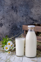 a bottle of milk and a glass of milk in a rustic table