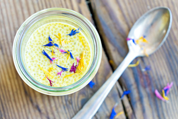 delicious yellow saffron chia pudding with edible dried flower
