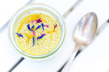 delicious yellow saffron chia pudding with edible dried flower
