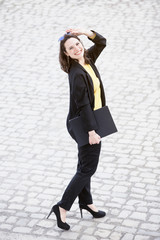 young woman walking and holding a book