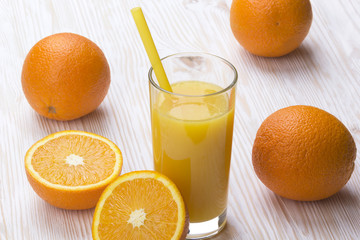 Orange juice in glass,  fresh fruits on wooden background