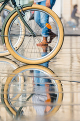 Fototapeta na wymiar People riding bicycles in the mirror fountain