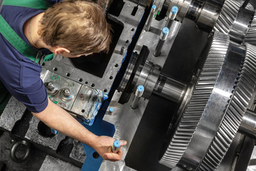 Working people with a small steam turbine. Metal gears. Gear wheels of the engine. © Anton Mikhmel