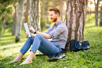 Obraz premium Handsome student reading in nature