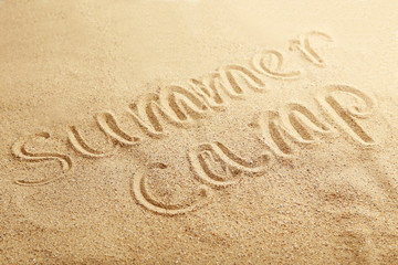 Summer camp handwritten in a beach sand