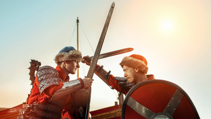 Battle of two medieval knights with swords and shields. Warship