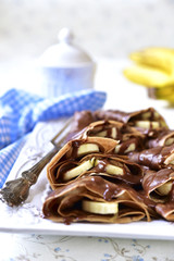 Chocolate pancakes with banana and chocolate sauce.