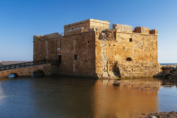 Old castle on Mediterranean sea coast. Paphos, Cyprus. Bright sunset light