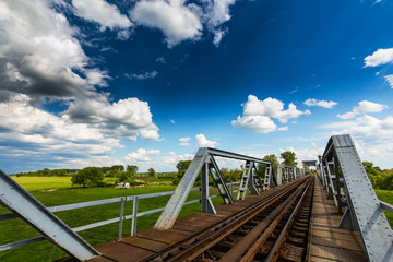 Old railroad bridge profiled on blue sky in summer