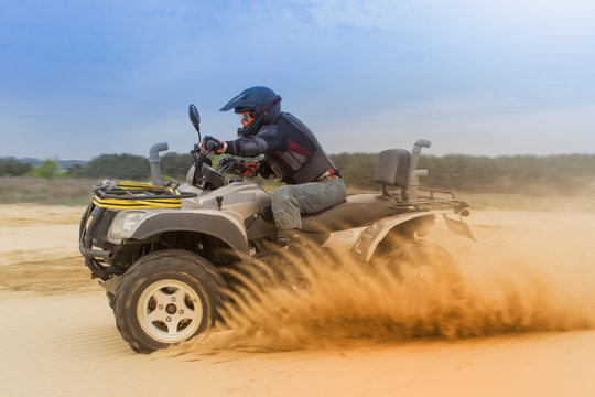 Racing ATV is sand. 