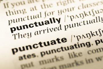 Fototapeta premium Close up of old English dictionary page with word punctually