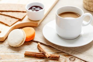 sweet breakfast with coffee and macaroons on wooden table