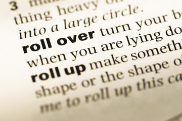 Obraz premium Close up of old English dictionary page with word roll over