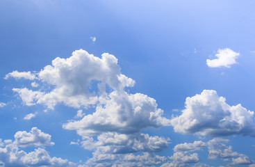 Blue sky with puffy white clouds in bright clear sunny day