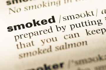 Close up of old English dictionary page with word smoked