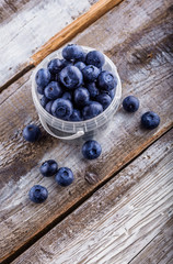 Blueberries in a plastic can on old rustic white wooden table