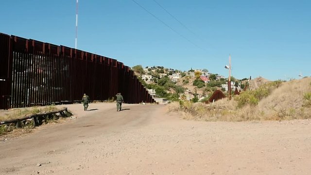 US Border Patrol agents investigate the fence at the Mexican border