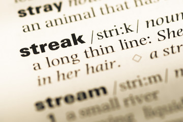 Fototapeta premium Close up of old English dictionary page with word streak