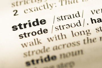 Obraz premium Close up of old English dictionary page with word stride