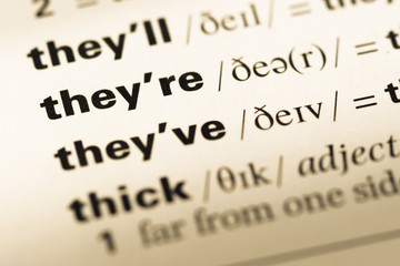 Obraz premium Close up of old English dictionary page with word they're