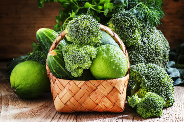 Wicker basket with green vegetables, fruits and herbs, vintage d