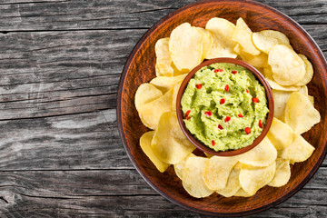 bowl of guacamole dip and potato chips