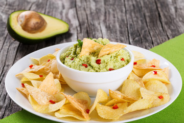 bowl of guacamole dip and potato chips