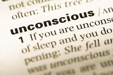 Close up of old English dictionary page with word unconscious