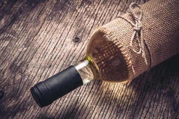 Bottle of white wine on rustic wooden background