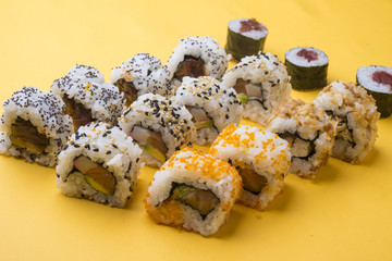 Various kinds of sushi food served on yellow blackground