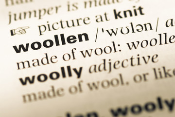 Obraz premium Close up of old English dictionary page with word woollen