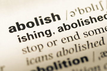 Close up of old English dictionary page with word abolish - obrazy, fototapety, plakaty