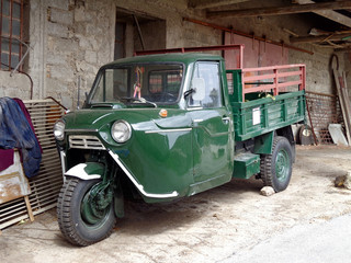Three-wheeled truck at the wall of the village house