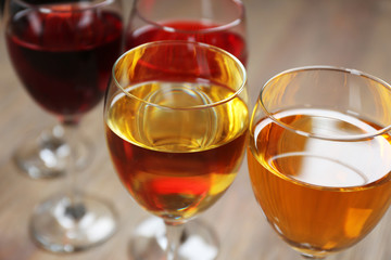 Glasses with wines of different colors on a wooden table