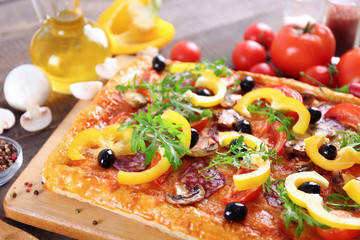 Rectangle delicious pizza and vegetables on the table, close-up