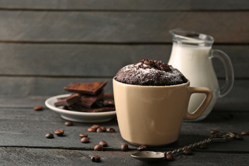 Chocolate fondant cake in cup on wooden background