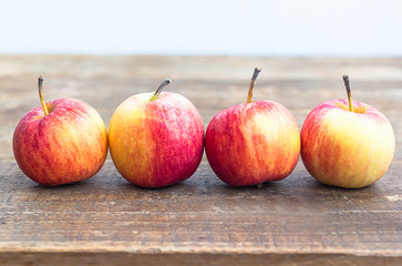 apples in row on wood table