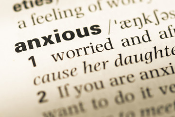 Close up of old English dictionary page with word anxious