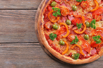 Tasty pizza with sausage and vegetables on wooden table background
