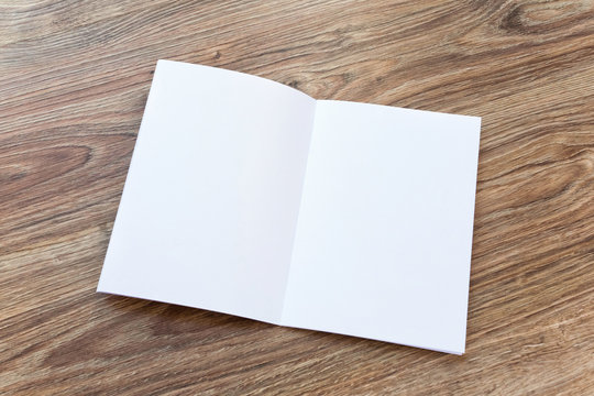 Open blank brochure, magazine is on a wooden desk