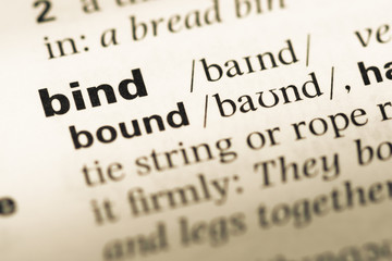 Close up of old English dictionary page with word bind