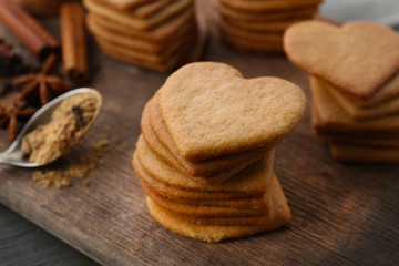 Heart shaped biscuits and cinnamon on cutting board
