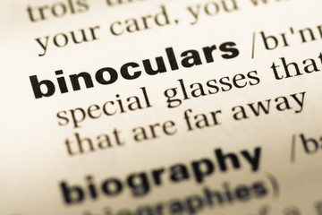 Obraz premium Close up of old English dictionary page with word binoculars