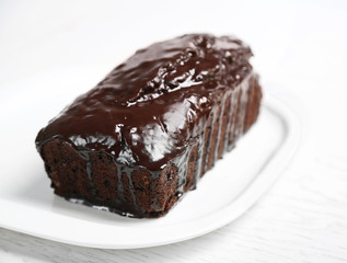 Chocolate cake with icing on white table