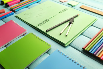 School set with notebooks, divider and colored pencils on wooden blue background